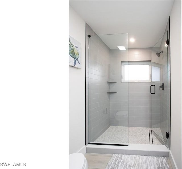 bathroom featuring an enclosed shower and toilet