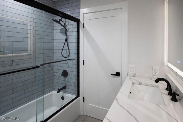 bathroom with sink and shower / bath combination with glass door