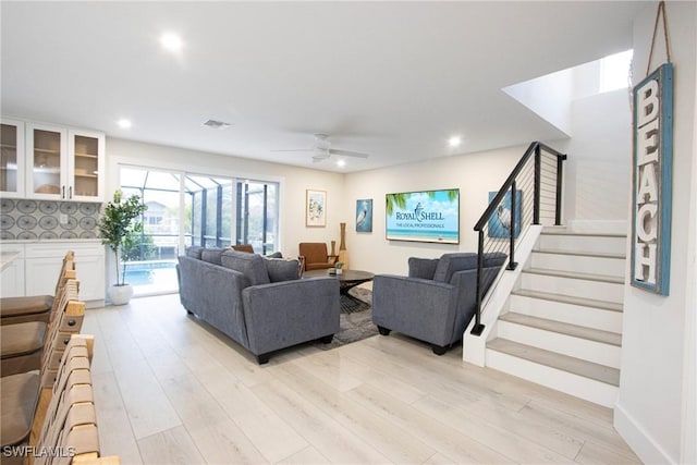 living room with light hardwood / wood-style flooring and ceiling fan