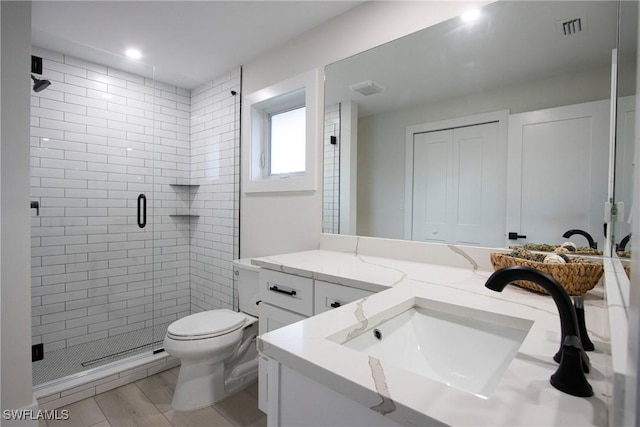 bathroom featuring vanity, an enclosed shower, and toilet