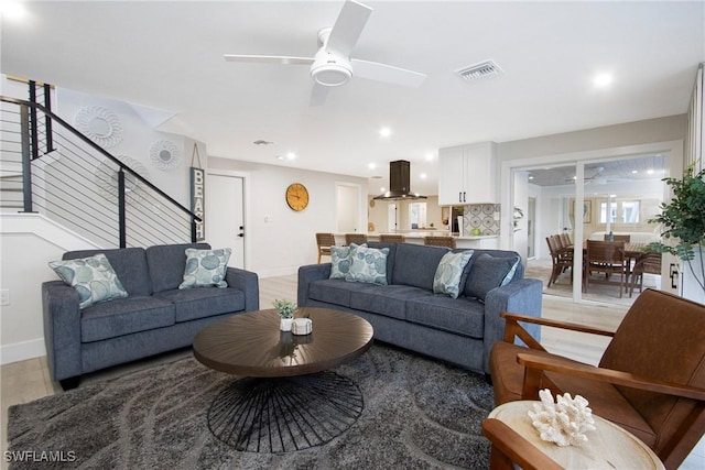 living room featuring ceiling fan and light hardwood / wood-style floors