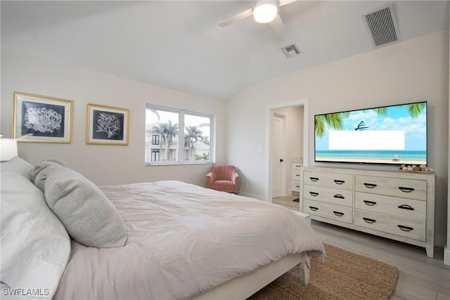 bedroom with ceiling fan, lofted ceiling, and light wood-type flooring