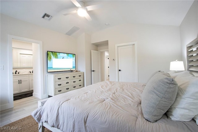 bedroom with sink, ensuite bath, light hardwood / wood-style flooring, ceiling fan, and vaulted ceiling