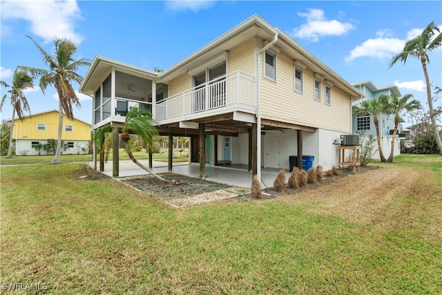 back of house featuring a lawn, a sunroom, ceiling fan, central AC unit, and a patio