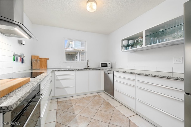 kitchen featuring black appliances, range hood, white cabinetry, and light stone countertops