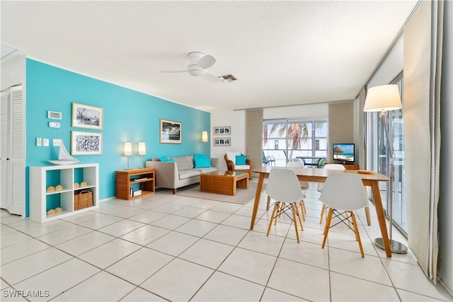 dining room featuring ceiling fan, light tile patterned floors, and a textured ceiling