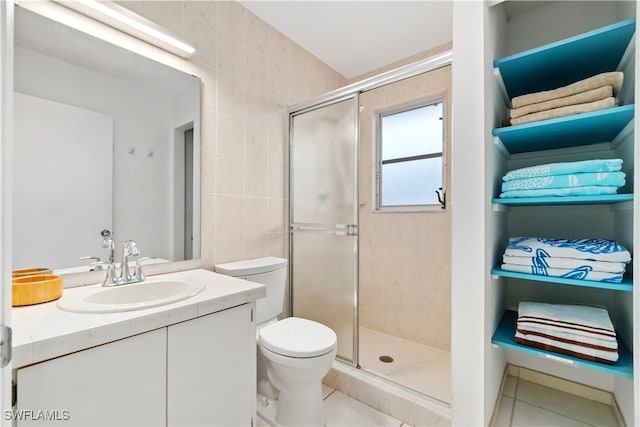 bathroom with tile patterned floors, vanity, an enclosed shower, and toilet