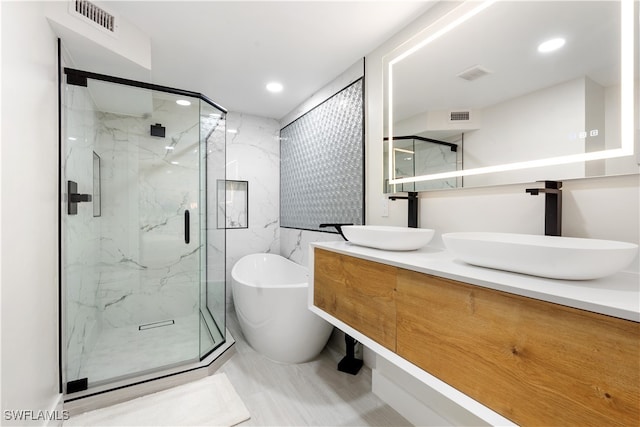 bathroom with vanity and separate shower and tub