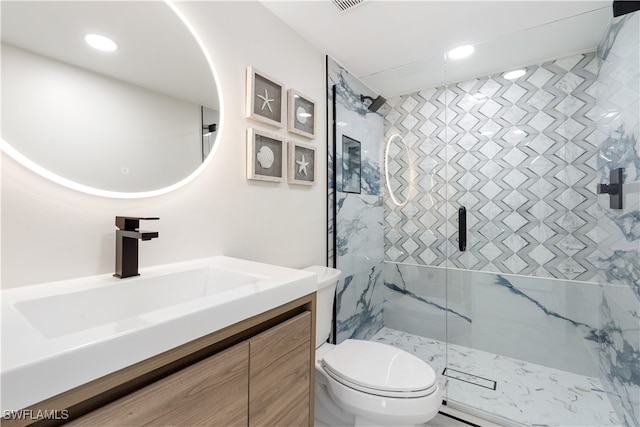 bathroom featuring vanity, an enclosed shower, and toilet