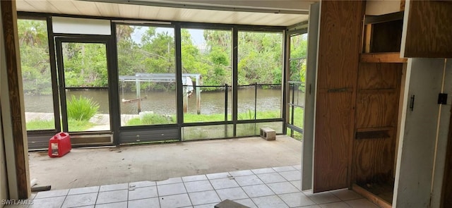 unfurnished sunroom with a water view