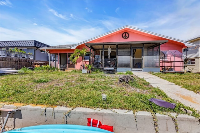 view of front of property with a sunroom and a front lawn