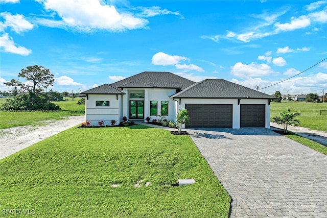 view of front of home with decorative driveway, a garage, a front lawn, and stucco siding