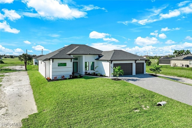 view of front of property featuring a front yard, a shingled roof, stucco siding, a garage, and decorative driveway