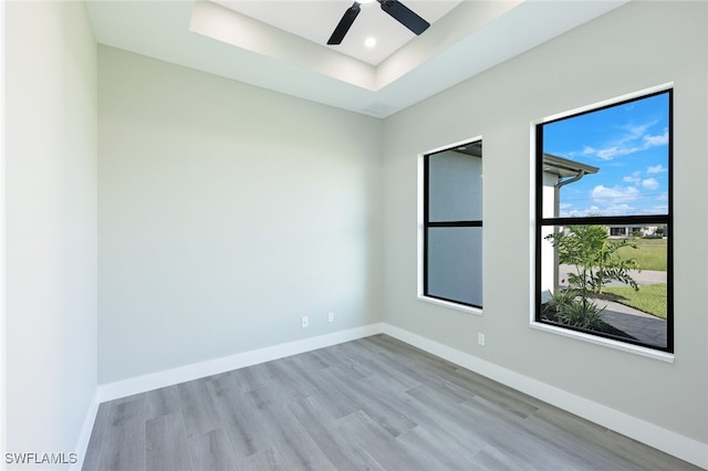 unfurnished room with ceiling fan, baseboards, recessed lighting, wood finished floors, and a raised ceiling