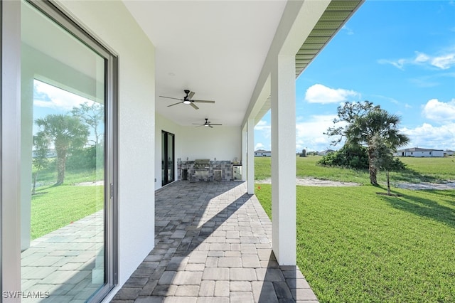 view of patio with an outdoor kitchen and ceiling fan