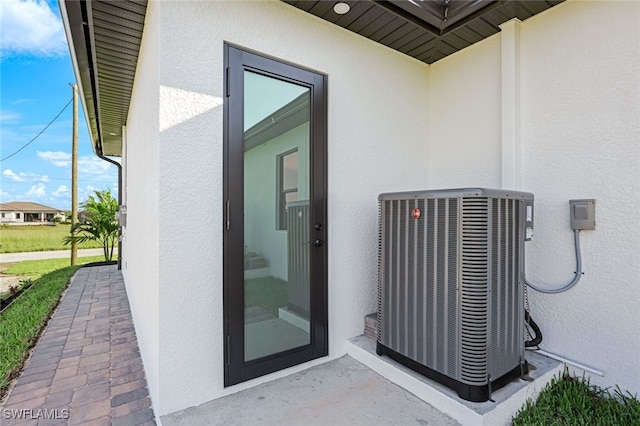 entrance to property featuring central air condition unit and stucco siding