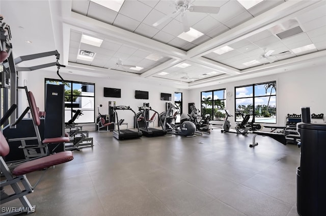 exercise room with ceiling fan, a paneled ceiling, and a wealth of natural light