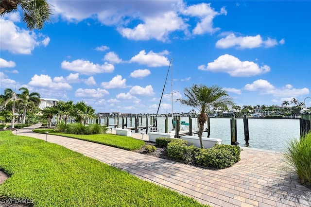 view of dock with a yard and a water view