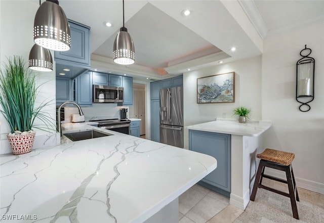 kitchen with sink, a breakfast bar area, hanging light fixtures, appliances with stainless steel finishes, and kitchen peninsula