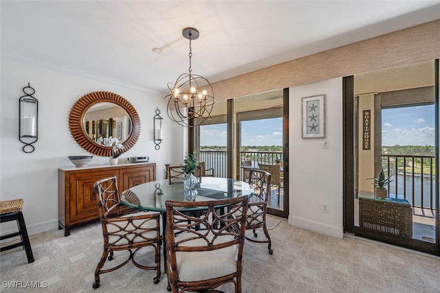 carpeted dining area with a water view, crown molding, and a chandelier