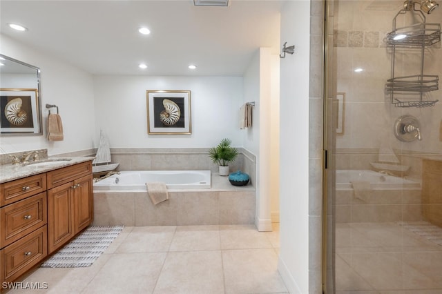 bathroom featuring tile patterned flooring, shower with separate bathtub, and vanity