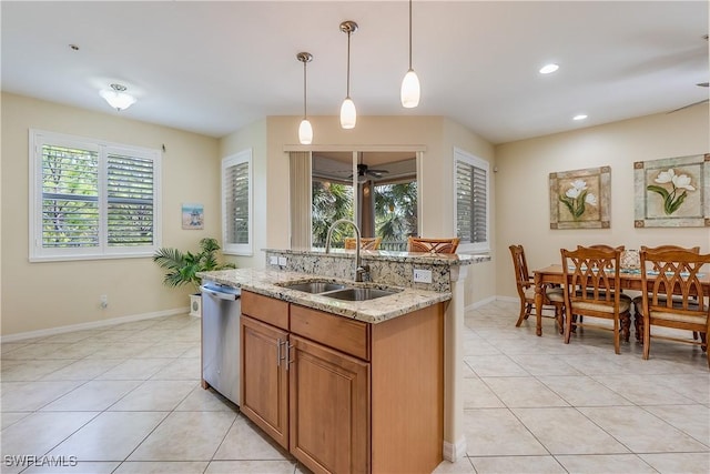 kitchen with a sink, light tile patterned floors, baseboards, and dishwasher
