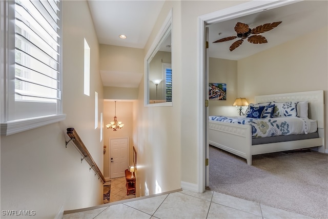 interior space featuring light colored carpet and ceiling fan with notable chandelier