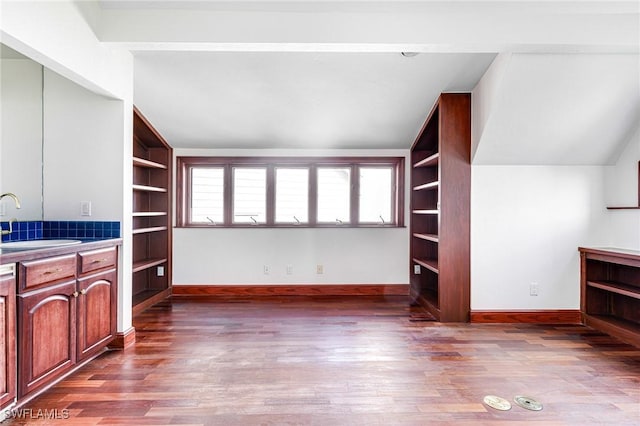 interior space with sink, wood-type flooring, and lofted ceiling