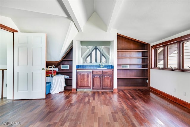 unfurnished living room featuring dark hardwood / wood-style flooring, lofted ceiling with beams, and sink