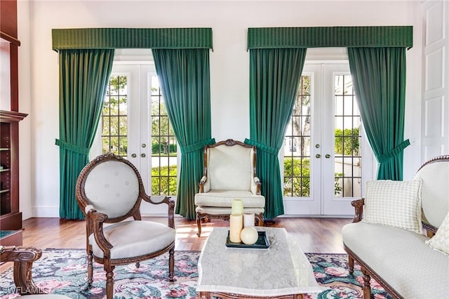 sitting room featuring french doors, plenty of natural light, and light hardwood / wood-style flooring