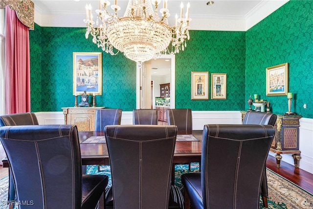 dining room with hardwood / wood-style floors, an inviting chandelier, and crown molding