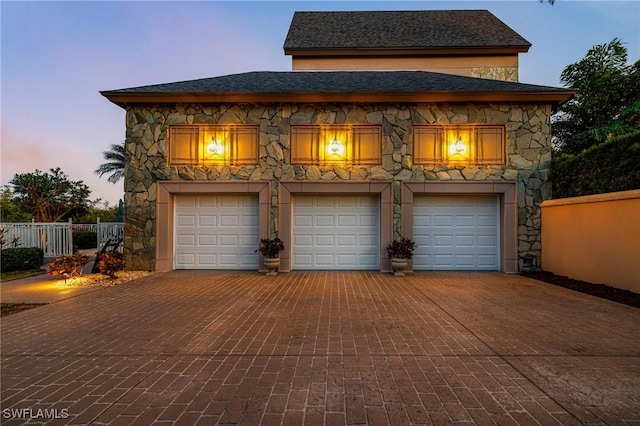 view of garage at dusk