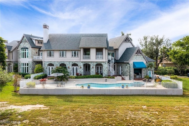 back of house with a fenced in pool, a yard, and a patio