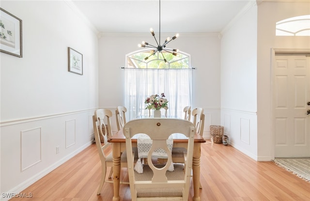 dining room featuring a notable chandelier, light wood-type flooring, and ornamental molding