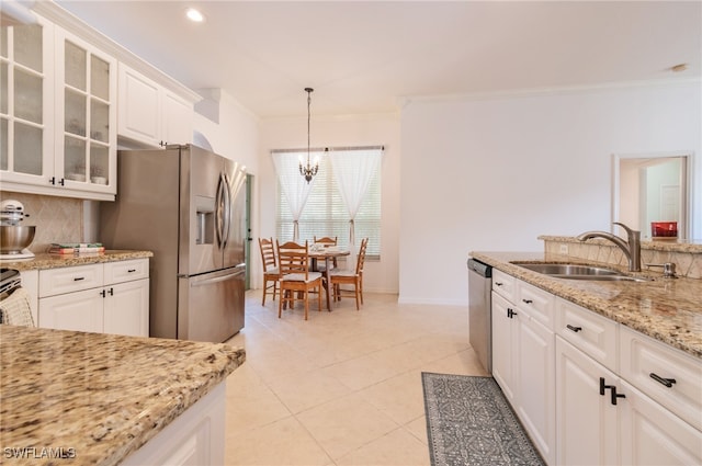 kitchen featuring decorative backsplash, decorative light fixtures, sink, and white cabinetry