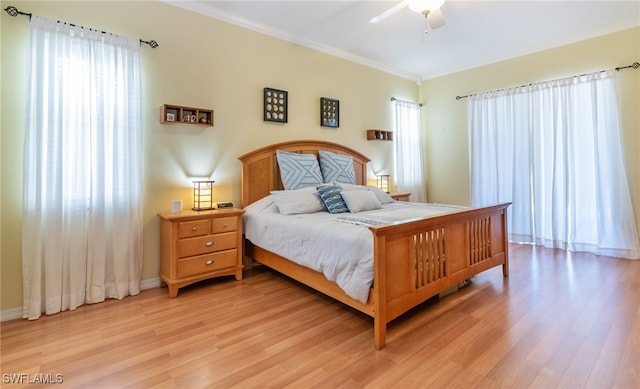 bedroom with ornamental molding, light hardwood / wood-style flooring, and ceiling fan