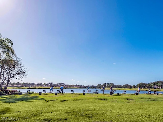 view of community with a water view and a yard