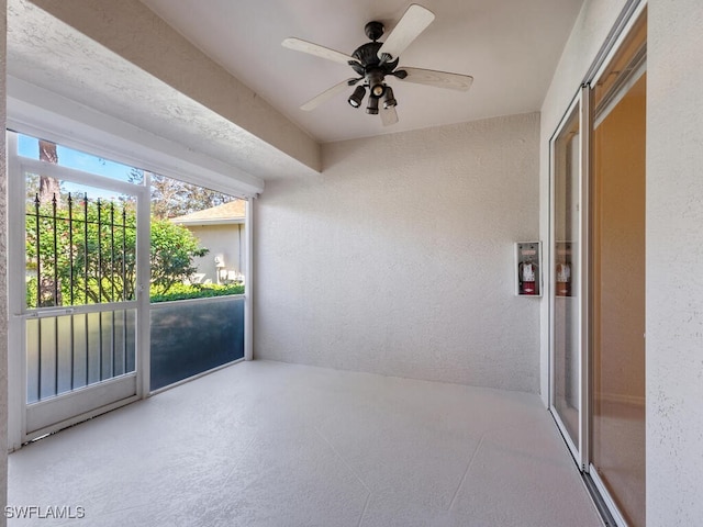 unfurnished sunroom featuring a barn door and ceiling fan