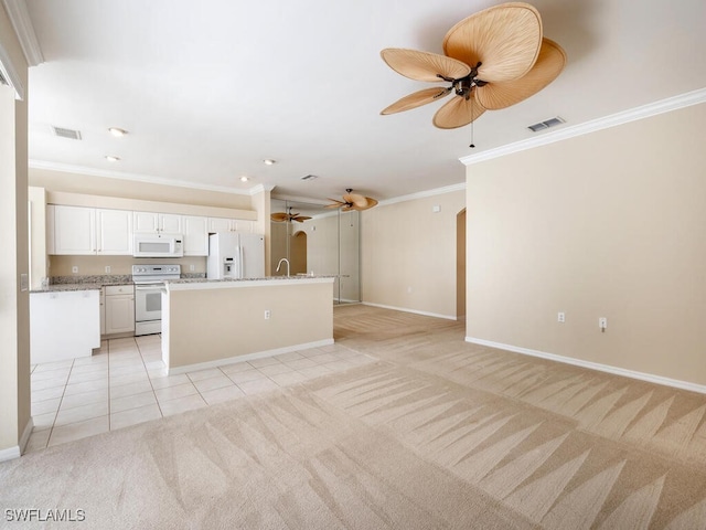 kitchen featuring white appliances, light tile patterned floors, visible vents, and light colored carpet