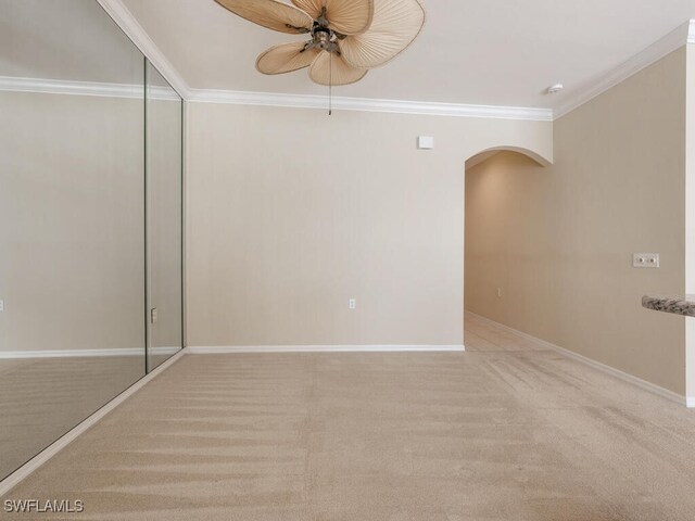 unfurnished room with ceiling fan, light colored carpet, and ornamental molding