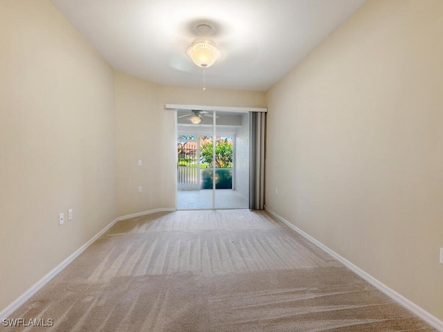 carpeted spare room with ceiling fan and baseboards