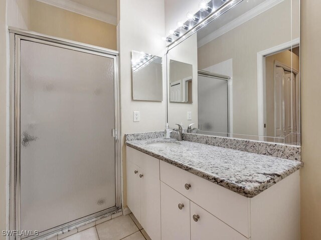 bathroom featuring tile patterned flooring, vanity, ornamental molding, and a shower with door