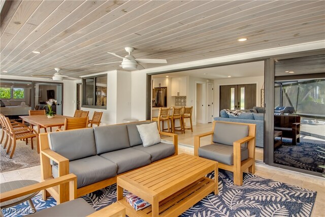 living room with plenty of natural light, wooden ceiling, and ceiling fan