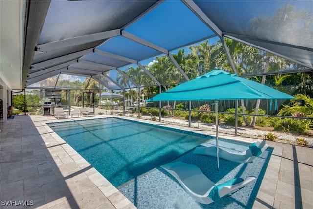 view of swimming pool featuring a patio and a lanai