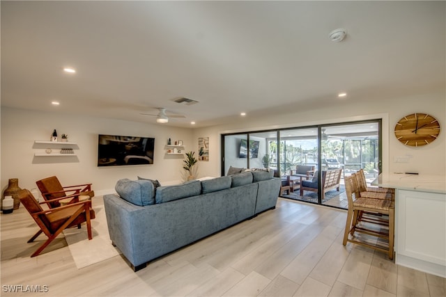 living room with light hardwood / wood-style floors and ceiling fan