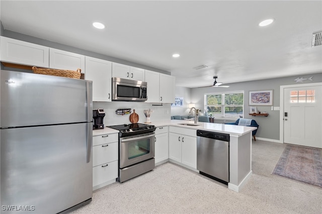 kitchen featuring ceiling fan, white cabinets, sink, kitchen peninsula, and appliances with stainless steel finishes