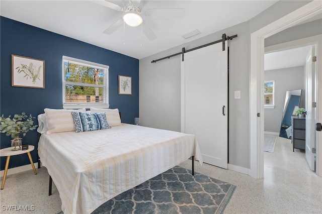 bedroom featuring a barn door and ceiling fan