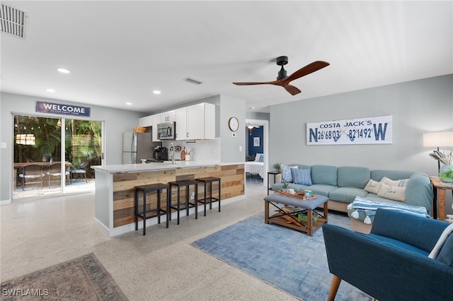 living room with ceiling fan and sink