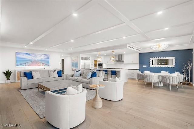 living room featuring light wood-style floors, recessed lighting, and beamed ceiling