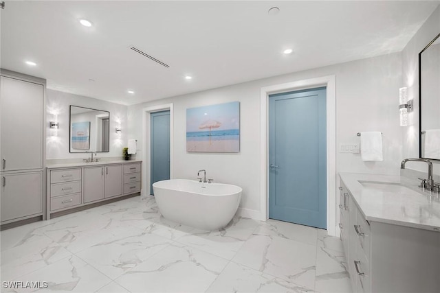 full bathroom featuring a sink, two vanities, recessed lighting, and a freestanding bath